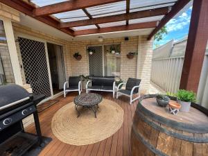 a patio with a grill and a table on a deck at Beachside Retreat 2 in Rockingham