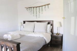 Un dormitorio con una cama con sábanas y almohadas blancas. en Rustic Chic 200 metres from CBD, en Bathurst