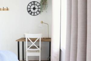 a desk with a chair and a clock on a wall at Rustic Chic 200 metres from CBD in Bathurst