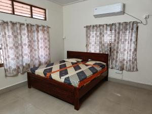 a bedroom with a bed and a window with curtains at Feel Like Home Rkbeach in Visakhapatnam