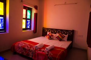 1 dormitorio con 1 cama con almohadas coloridas en Bhavyam Heritage Guest House, en Jodhpur