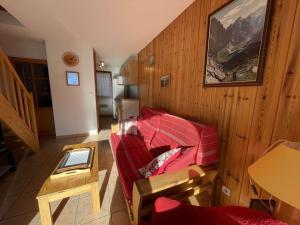 a living room with a red couch and a table at Appartement Saint-Chaffrey , 3 pièces, 6 personnes - FR-1-330E-21 in Saint-Chaffrey