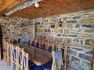 ein Esszimmer mit einer Steinmauer sowie einem Tisch und Stühlen in der Unterkunft Мах. Зоренишки дол 