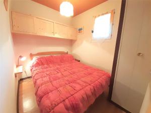 a bedroom with a bed with a red comforter at Appartement T2 pour 6 personnes, balcon, parking, St-Lary-Soulan - FR-1-457-142 in Saint-Lary-Soulan