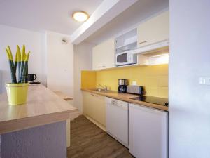 a kitchen with white cabinets and yellow tiles at Appartement Confort 10 Pers. à Peyragudes - 3 Ch, Balcon Sud, Près des Pistes - FR-1-695-1 in Germ