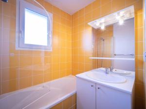 een badkamer met een wastafel, een bad en een raam bij Appartement Peyragudes, 3 pièces, 8 personnes - FR-1-695-5 in Germ