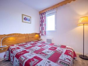 1 dormitorio con 1 cama con edredón rojo y blanco en Appartement Peyragudes, 3 pièces, 8 personnes - FR-1-695-5 en Germ