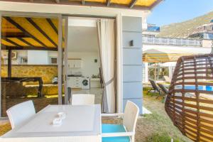 patio con mesa y sillas y cocina en Nur Suites & Hotels, en Kalkan
