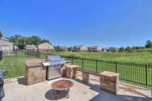 a grill and smoker on a patio with a field at The Muirwood Retreat in Murfreesboro