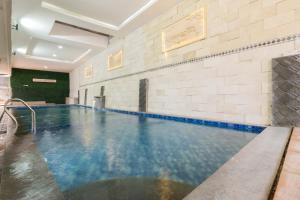 an indoor swimming pool with blue and white tiles at Urbanview Hotel Kampung Istal Megamendung Puncak by RedDoorz in Cipayung