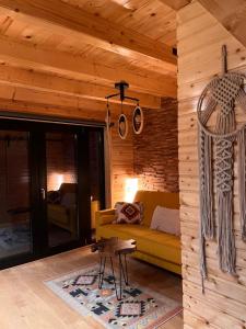 a living room with a yellow couch and a table at MoodySun Studio, remote tiny home in Comarnic