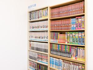 un estante de libros lleno de DVD en Hirononomori Maehama Bekkan Male Only, en Hirono