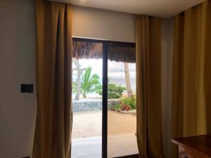 una porta scorrevole in vetro con vista sulla spiaggia di Beatriz Rafaela Resort 