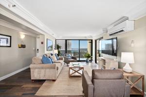 a living room with two couches and a table at Expansive Lanai w/ Panoramic Views - Walk to Waikiki Beach in Honolulu