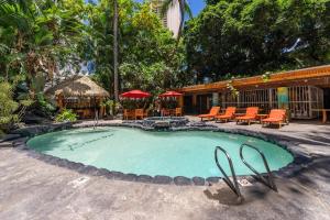 a large swimming pool with orange chairs and tables at Expansive Lanai w/ Panoramic Views - Walk to Waikiki Beach in Honolulu