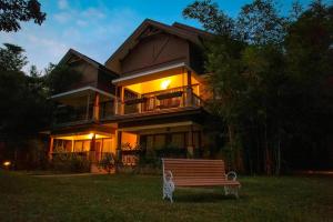 a house with a wooden bench in front of it at Morickap Resort in Vythiri