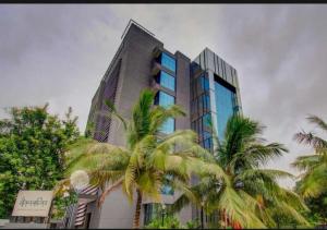 a tall building with palm trees in front of it at The Park Infinity in Surat