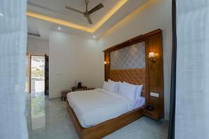 a bedroom with a large white bed in a room at Yellow Tail by Puggles Resorts in Rāmnagar
