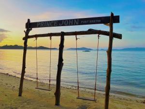 a sign on a beach with swings on it at Prince John beachfront cottages and Restaurant in San Vicente