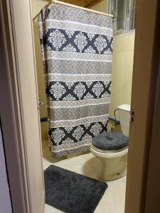 a bathroom with a shower curtain and a toilet at MiaDa’bia in Madaba