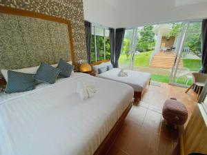 een slaapkamer met 2 bedden en een groot raam bij ภูฝ้ายวิลล่า Phufai villa in Chiang Khan