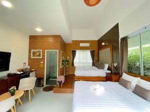 a hotel room with a large bed and a bathroom at ภูฝ้ายวิลล่า Phufai villa in Chiang Khan +81 photos
