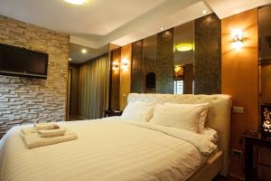 a bedroom with a large bed with a tv on the wall at 2D-Short-term rental allowed-3BRs Downtown Bangkok in Makkasan +98 photos