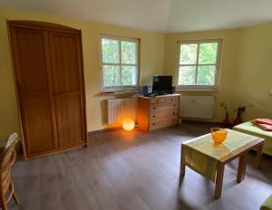 a living room with a bed and a dresser with a table at Nationalparkresidenz in Lindberg