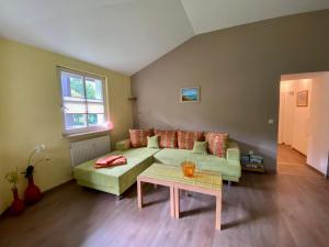 sala de estar con sofá verde y mesa en Nationalparkresidenz, en Lindberg