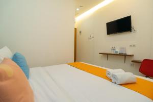 Postel nebo postele na pokoji v ubytování Sans Hotel Suryakencana Bogor