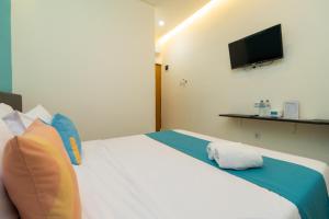 Postel nebo postele na pokoji v ubytování Sans Hotel Suryakencana Bogor