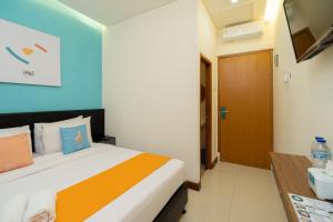 Postel nebo postele na pokoji v ubytování Sans Hotel Suryakencana Bogor + 32 fotografií