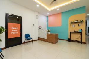 una oficina con una sala de espera con una puerta y una silla en Sans Hotel Suryakencana Bogor en Bogor
