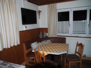 a dining room with a table and chairs and windows at Ferienhaus Durig in Gaschurn