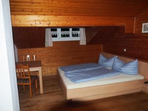 a small bedroom with a bed and a desk at Ferienhaus Durig in Gaschurn