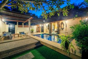 een villa met een zwembad in de nacht bij Chada Lanta Beach Resort - SHA Extra Plus in Koh Lanta