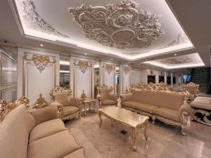 een woonkamer met banken en een kroonluchter bij Puteri Wing - Riverside Majestic Hotel in Kuching
