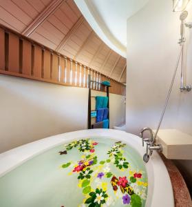 a bathroom with a bath tub with flowers on it at Chada Lanta Beach Resort - SHA Extra Plus in Ko Lanta