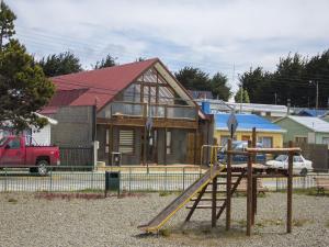 a wooden building with a surfboard on top of it at Hostel Entre Vientos in Punta Arenas