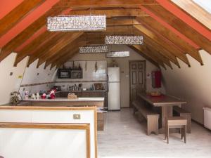 a kitchen with wooden ceilings and a kitchen with a table at Hostel Entre Vientos in Punta Arenas