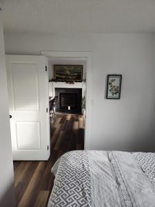 1 dormitorio con 1 cama y 1 habitación con chimenea en Tranquil & Tasteful One Bdrm Private Suite NE en Edmonton