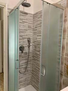 La salle de bains est pourvue d'une douche avec une porte en verre. dans l'établissement Gigogì House, à Milan