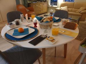 a white table with breakfast foods and orange juice on it at Bij de oude dijk in Wilp