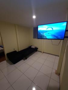 een woonkamer met een grote flatscreen-tv aan de muur bij LIndo departamento a 10 min en bus al centro historico de Lima in Lima