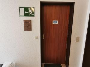 une porte dans une pièce avec un panneau sur le mur dans l'établissement FeWo Jadeblick - Horumersiel, à Horumersiel