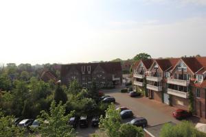 une vue aérienne sur une ville avec des voitures garées dans un parking dans l'établissement FeWo Jadeblick - Horumersiel, à Horumersiel