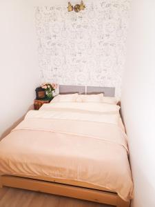Bett in einem Schlafzimmer mit Tapeten an der Wand in der Unterkunft Apartament LABA in Sosnowka