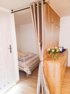 ein Schlafzimmer mit einem Bett und einem Tisch mit einer Blumenvase in der Unterkunft Apartament LABA in Sosnowka