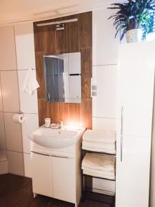 La salle de bains est pourvue d'un lavabo blanc et d'un miroir. dans l'établissement Apartament LABA, à Sosnówka
