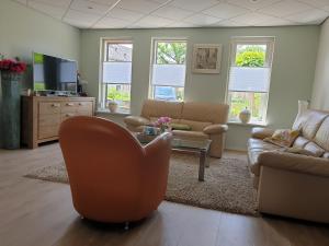 ein Wohnzimmer mit einem Sofa und einem Stuhl in der Unterkunft Bij de oude dijk in Wilp